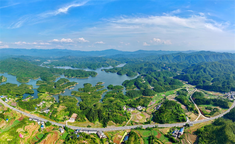Jiangxi : à Ruijin, la route serpente à travers le paysage et les voitures traversent une nature luxuriante