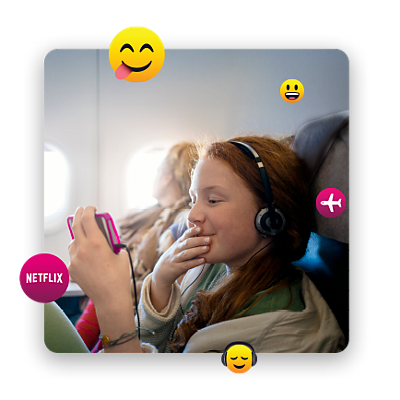 Girl smirking as she streams on her phone, inside an airplane, surrounded by emojis.