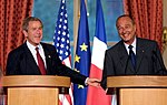Die Amerikaanse en Franse presidente, George W. Bush en Jacques Chirac, met hul onderskeidelike nasionale vlae agter hulle
