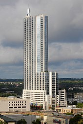 Photograph of a skyscraper that suddenly narrows asymmetrically about half-way to the top