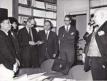 Dans les bureaux d'Europe en 1966. Jacques Gaucheron tenant un livre, Armand Monjo et Pierre Gamarra devant la porte, et Pierre Abraham fumant la pipe, et trois écrivains vietnamiens (non identifiés).