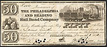 Philadelphia and Reading Railroad Company 50 dollar bill. Bill has several small circular holes punched through the signatures of the Treasurer and Engineer. Images include Liberty, seated, with shield, caduceus, and sailing vessels; a busy railway station with cars on four different tracks; and a horse.