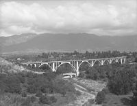 The Colorado Street Bridge, with the San Gabriel mountains in the background, around 1920.