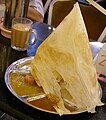 Image 10Roti tisu served as a savoury meal, pictured here with a glass of teh tarik. (from Malaysian cuisine)