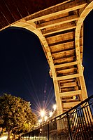 The Colorado Street Bridge 2020; view at night underneath with passing traffic and park lights.