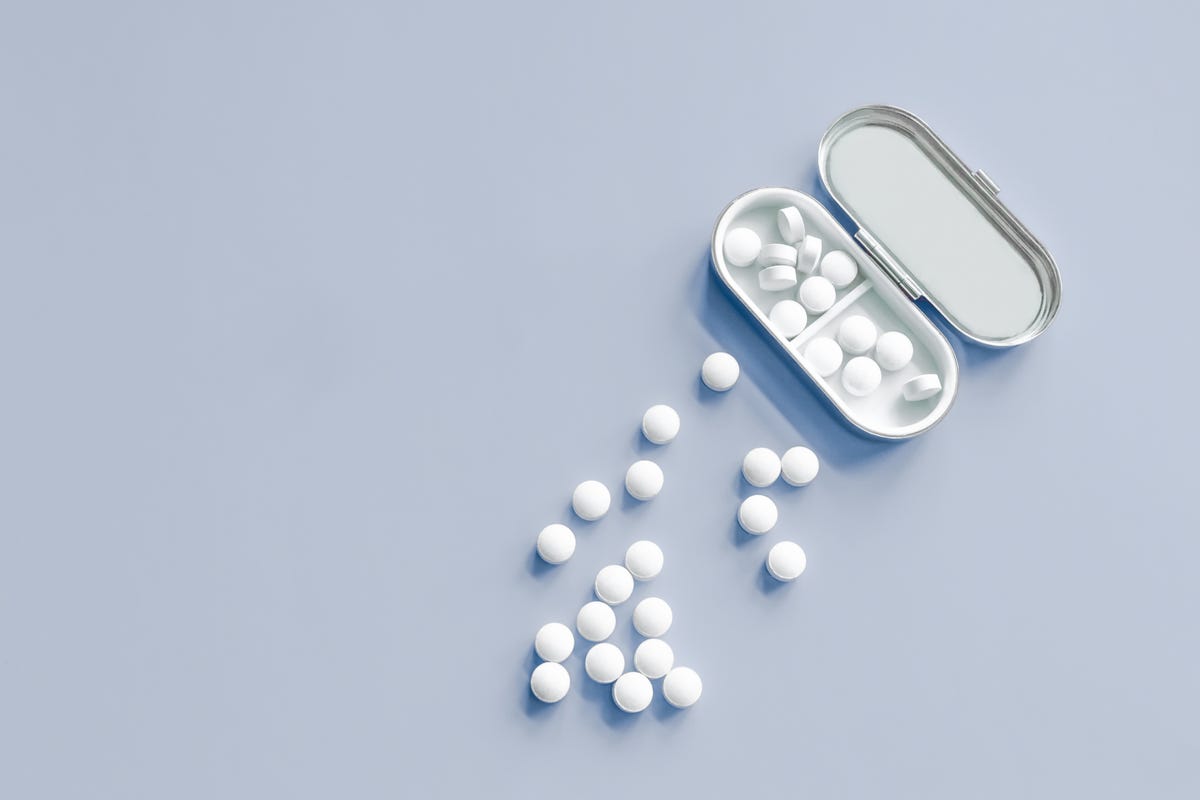 A box of white pills on a light blue background
