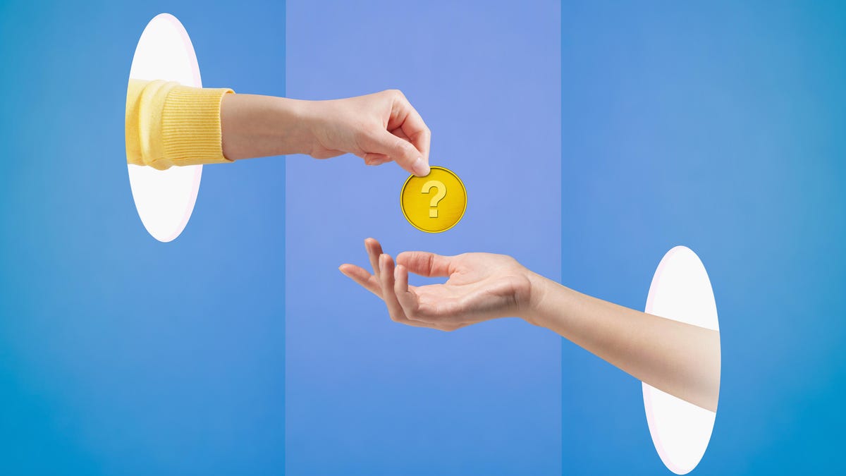 One woman&apos;s hand holding coin with a question mark over another woman&apos;s hand.