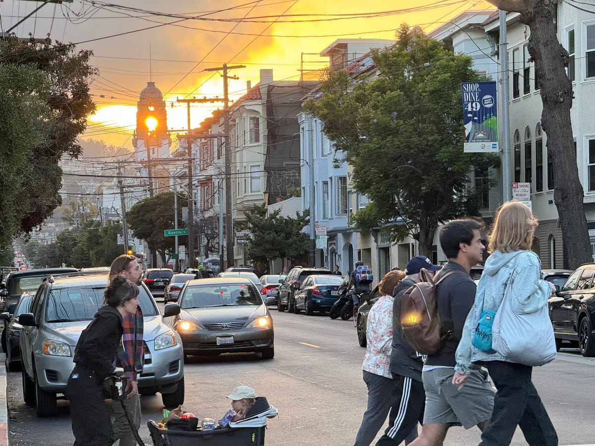 A photo of people walking at sunset