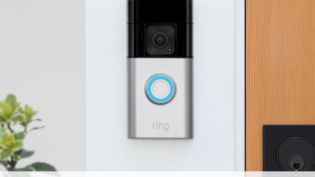 The Ring Battery Doorbell Plus against white door trim.