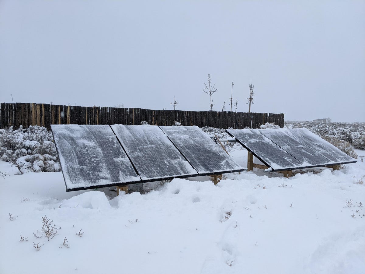 Ground-mounted solar panels in the snow.