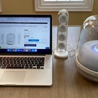 A laptop is flanked by Harman Kardon Soundsticks 4 speakers for PC.
