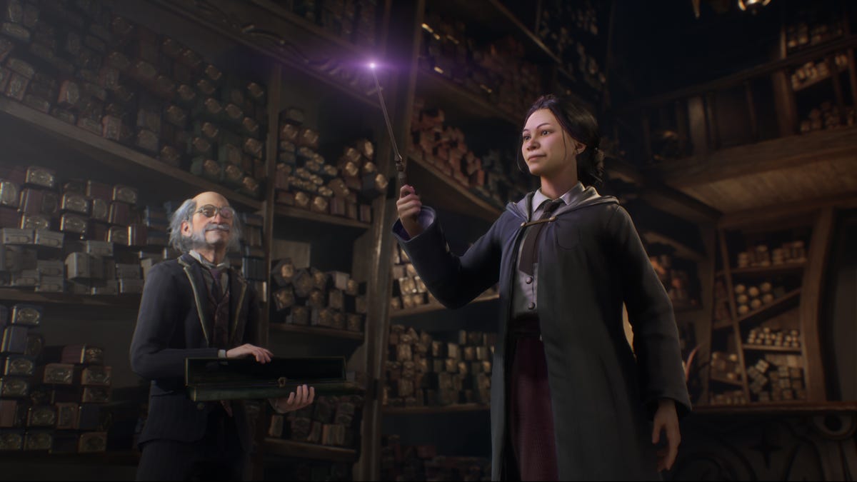 A student witch makes a purple magic light appear at the tip of their wand as the shopkeeper looks on Hogwarts Legacy