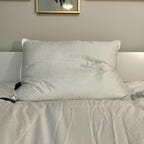 Brooklinen Down Pillow on a white bed.