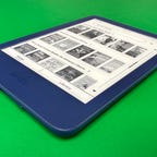 A side view of the Kindle 2022 in dark blue, against a green background