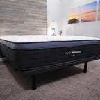 The Helix Midnight Luxe mattress sitting on top of a bed frame in a well-lit room.