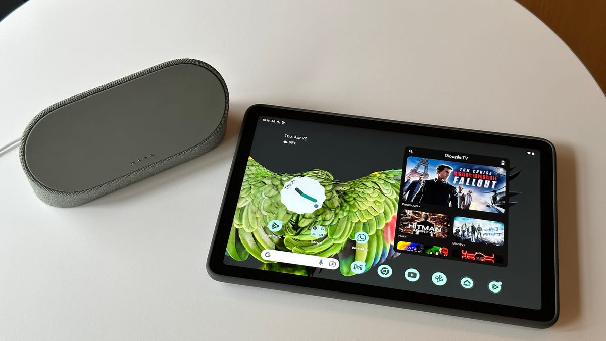 Google Pixel Tablet in black lying on a white table next to a charging dock