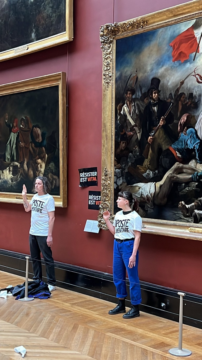 Après avoir collé les affichettes, les deux activistes se sont positionnés devant le chef-d'œuvre de Delacroix. ©Riposte alimentaire