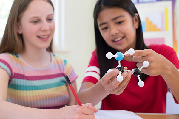 Two students examining a model of a molecule
