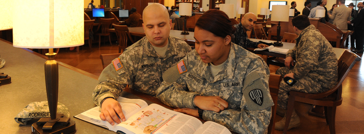 Bronx Community College Veterans Banner with student veterans Rafael Monteagudo (l) and Milissa Rodriguez, US Army in the BCC library