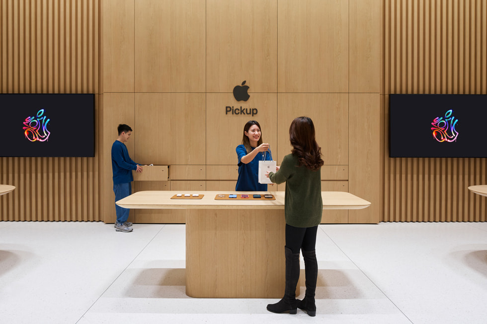 A customer speaks with a team member at the store’s dedicated Apple Pickup area.