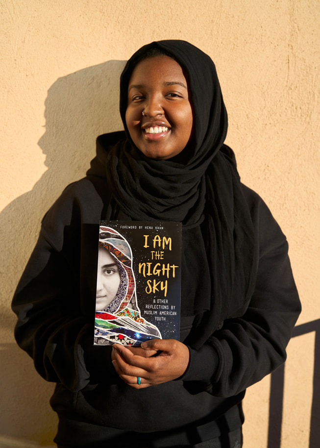 Sasa Aakil, participante da Shout Mouse Press, posa com uma cópia do livro de sua coautoria, I Am the Night Sky.