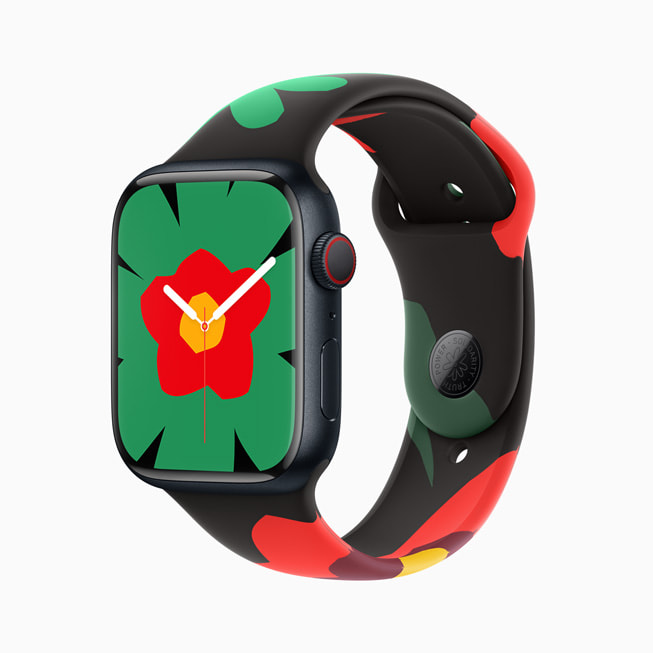 Imagem do Apple Watch Series 9 com a nova pulseira e mostrador da Coleção Black Unity; nesta imagem, o mostrador tem uma grande flor verde com um centro vermelho e amarelo.