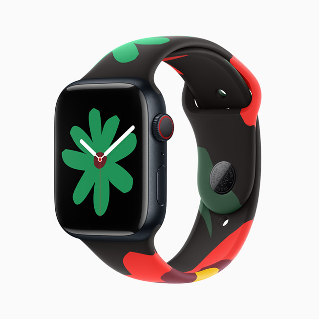 Imagem do Apple Watch Series 9 com a nova pulseira e mostrador da Coleção Black Unity; nesta imagem, o mostrador tem uma flor verde menor.