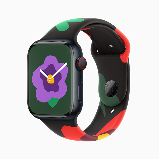 Imagem do Apple Watch Series 9 com a nova pulseira e mostrador da Coleção Black Unity; nesta imagem, o mostrador tem uma flor roxa menor.
