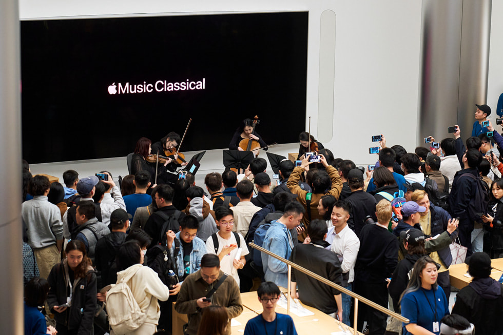 Los jóvenes miembros de la Orquesta Sinfónica de Shanghái tocan dentro de Apple Jing’an como parte de los festejos de inauguración de la tienda. 