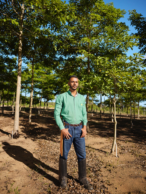 Victor Leon Rocha Araújo 穿著及膝靴，站在大西洋沿岸森林的一排樹中。