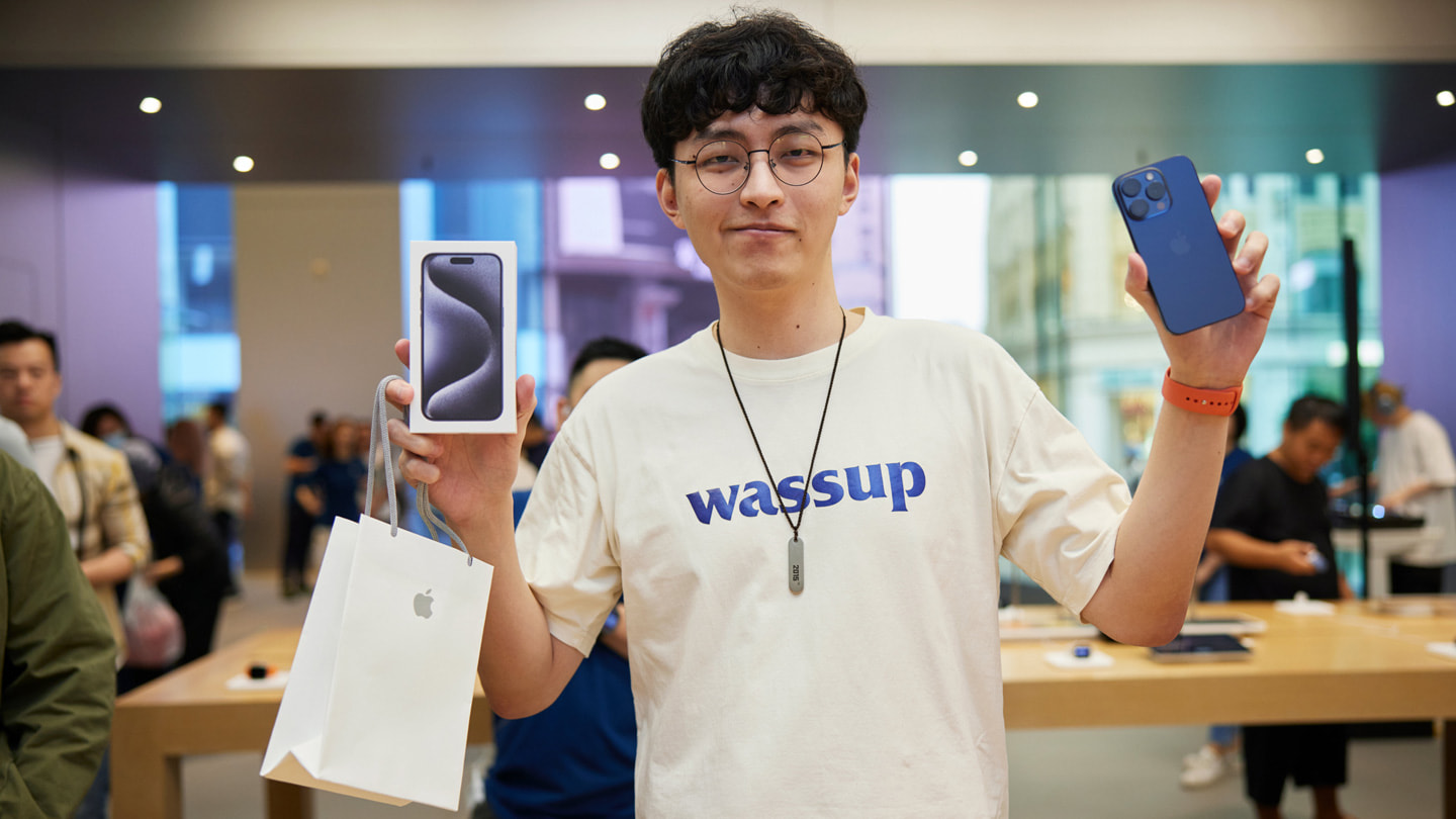 Een jonge klant showt zijn nieuwe blauwe iPhone 15 Pro Max.