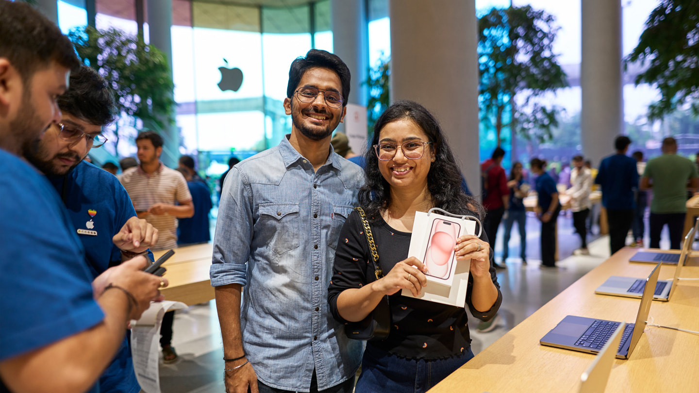 Two customers pose with their iPhone 15 purchase inside Apple BKC in Mumbai.