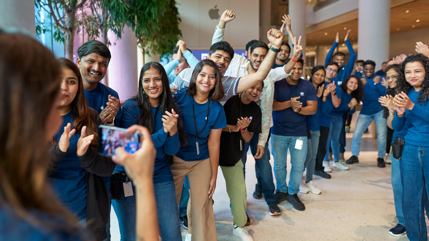  Apple BKC team members applaud as the first iPhone 15 customers enter the store.