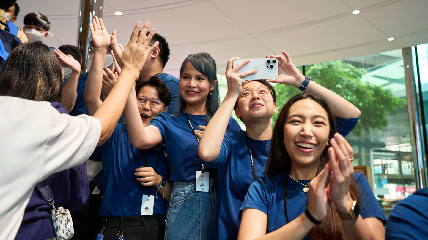 iPhone 15の最初のお客様の入店を祝うApple Central Worldのチームメンバー。