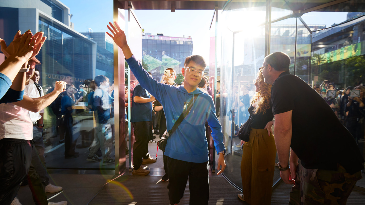 Team members welcome customers as they enter Apple Sanlitun.