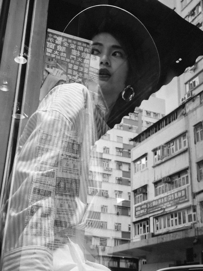 Ein Schwarz-Weiss-Foto von einer Person, die an einem Fenster sitzt und nach draussen schaut, aufgenommen mit einem iPhone 15 Pro Max.
