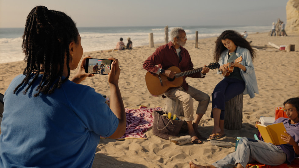 Eine Person, die ein räumliches Video mit einem iPhone 15 Pro am Strand aufnimmt.
