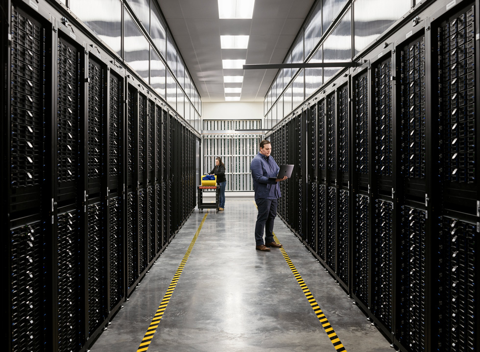 Two employees in a server room of an Apple data center.
