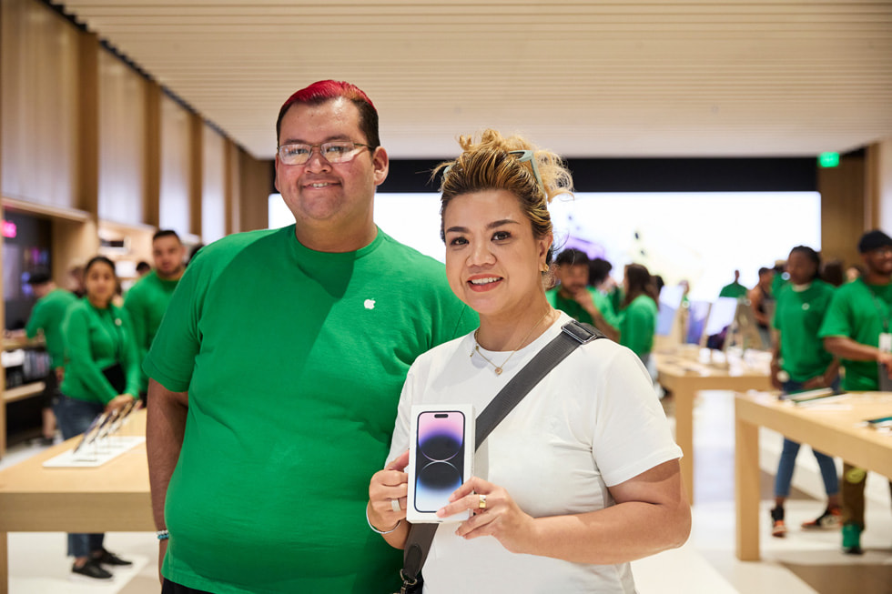 A customer shows off their new iPhone 14 Pro purchase.