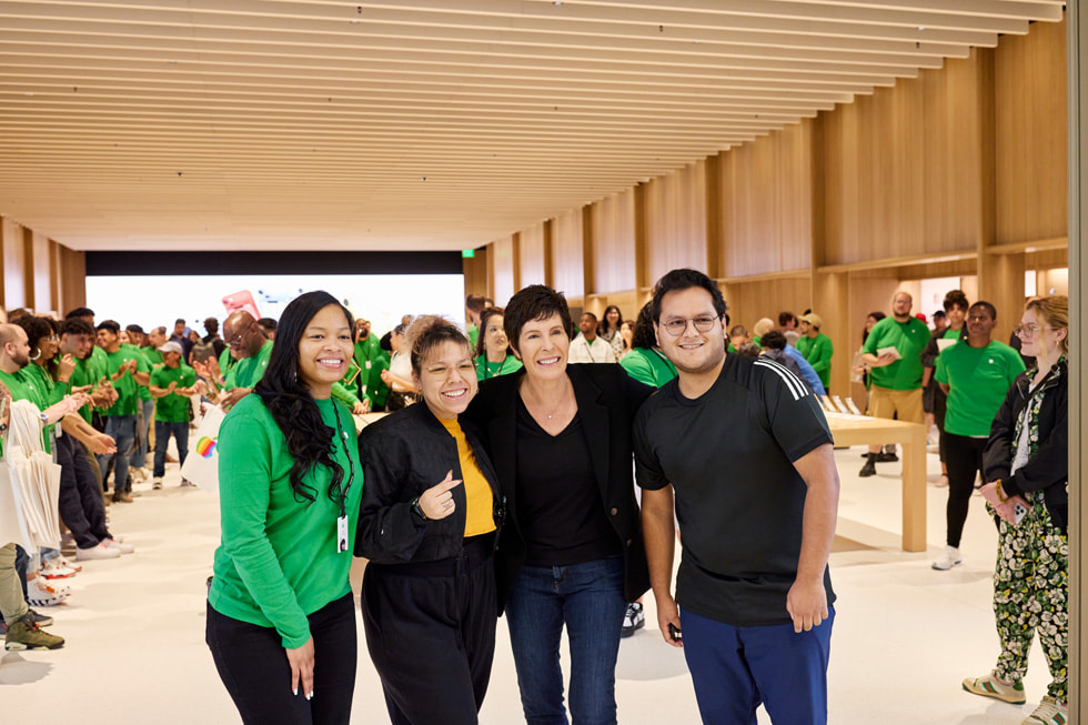 An Apple team member, a customer, Deirdre O’Brien, and another customer pose at the reopening of Apple Tysons Corner.