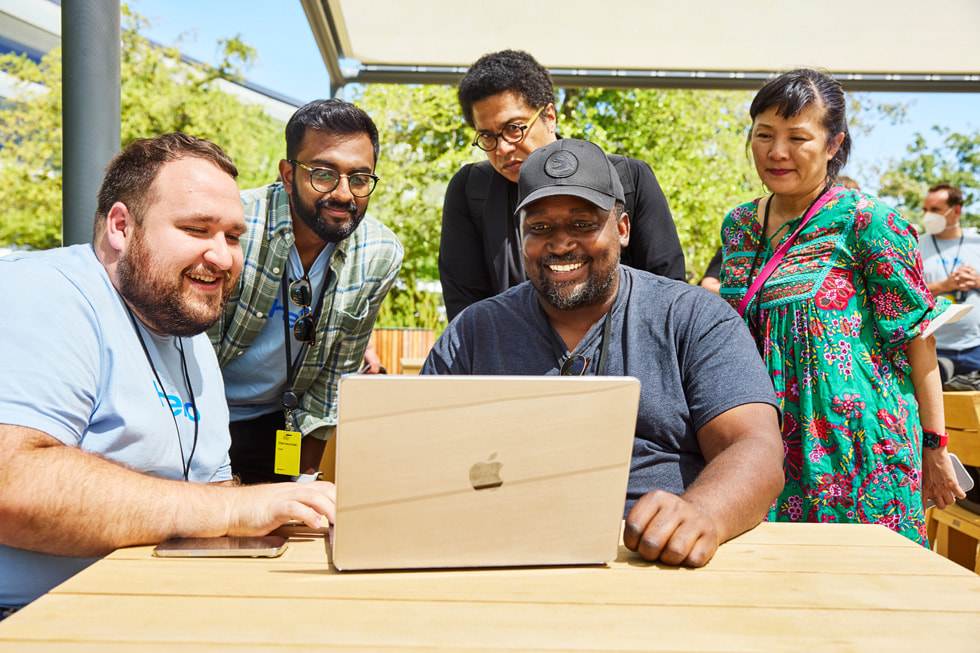 Inżynier Apple prowadzi pokaz dla grupy uczestników konferencji WWDC22 na kampusie Apple Park.