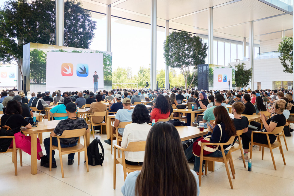 Uczniowie i studenci obecni na konferencji WWDC22 oglądają prezentację dotyczącą SwiftUI.