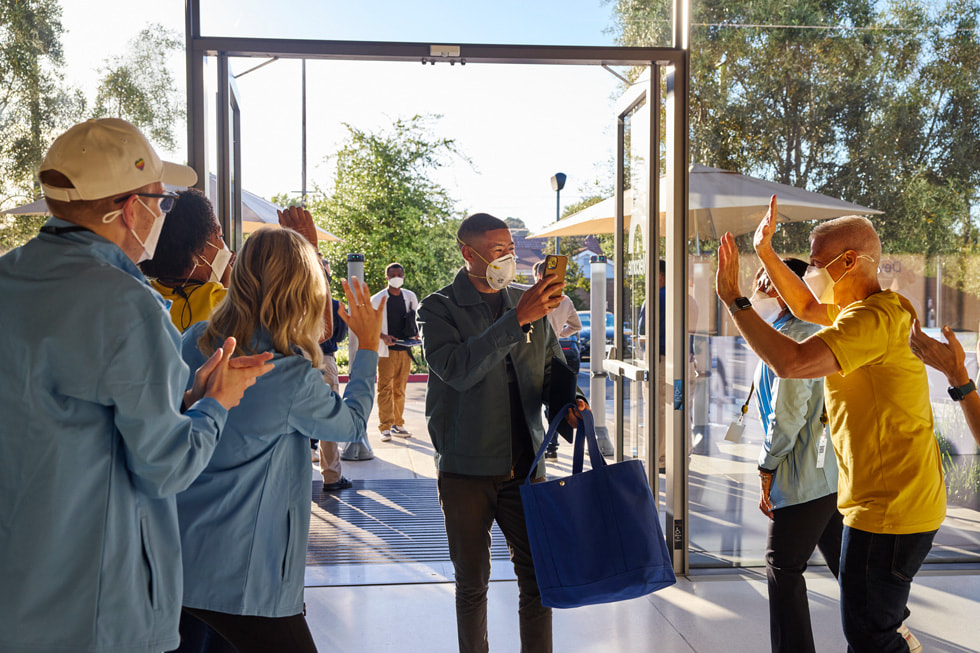 Członkowie zespołu konferencji WWDC22 witają deweloperów pojawiających się na kampusie Apple Park.