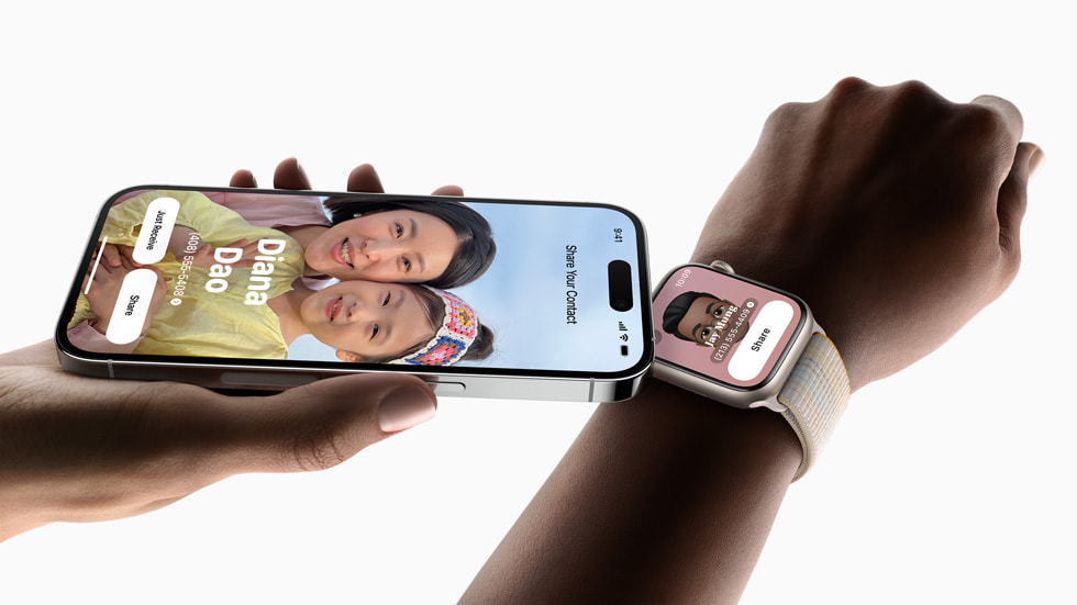 A hand holding iPhone 14 Pro is shown using NameDrop to share a contact to a user wearing Apple Watch Series 8..