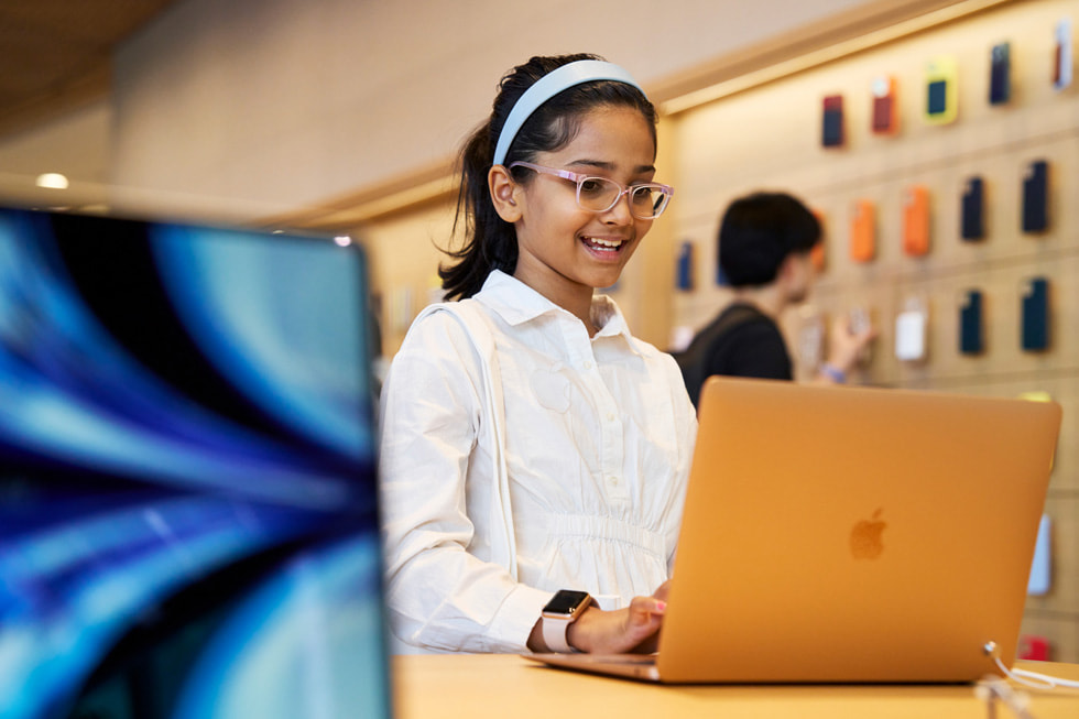 عميلة صغيرة السن تستخدم MacBook Air في متجر Apple BKC.
