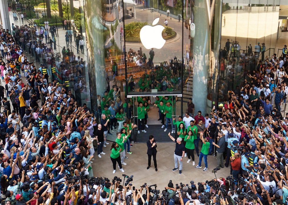 Tim Cook, Deirdre O’Brien, and team members applaud the first customers to Apple BKC.