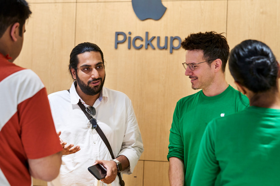 Des membres de l’équipe aident un client à la station de cueillette d’Apple Saket.