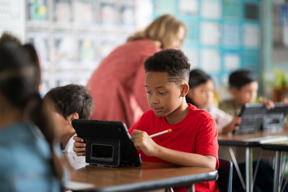 Młody uczeń z okręgu szkolnego Downey Unified School District używa iPada podczas lekcji.