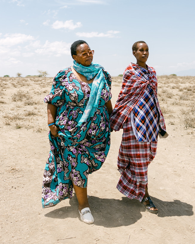 Mama Esther, que presta assistência à comunidade, e Neema caminham no deserto da Tanzânia.