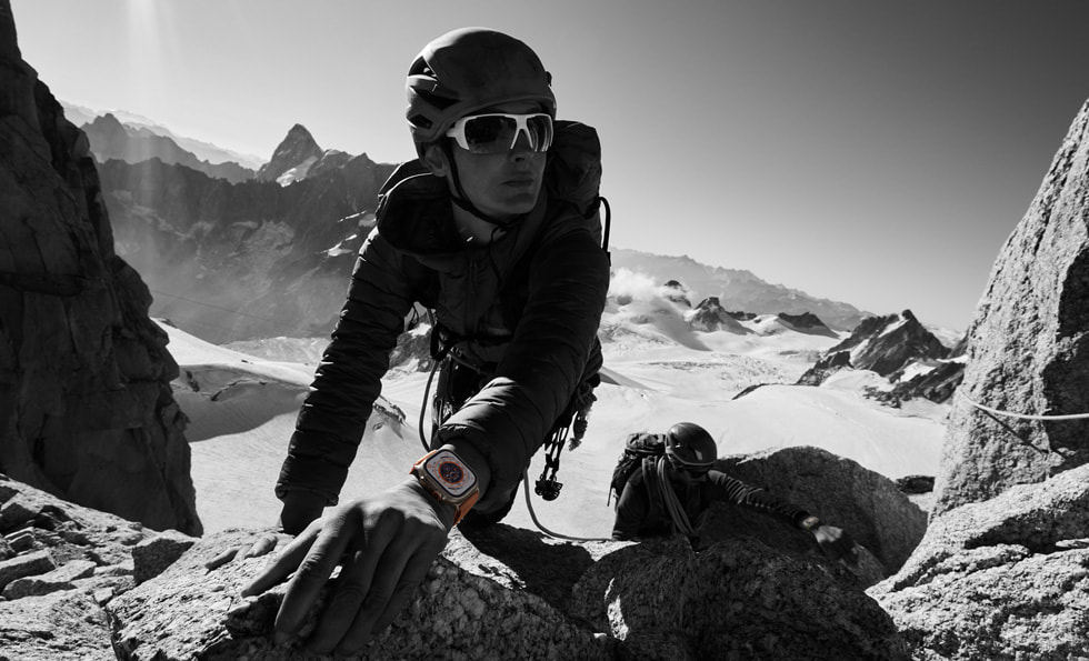在山嶽中，一名人士一邊攀石、一邊使用 Apple Watch Ultra。
